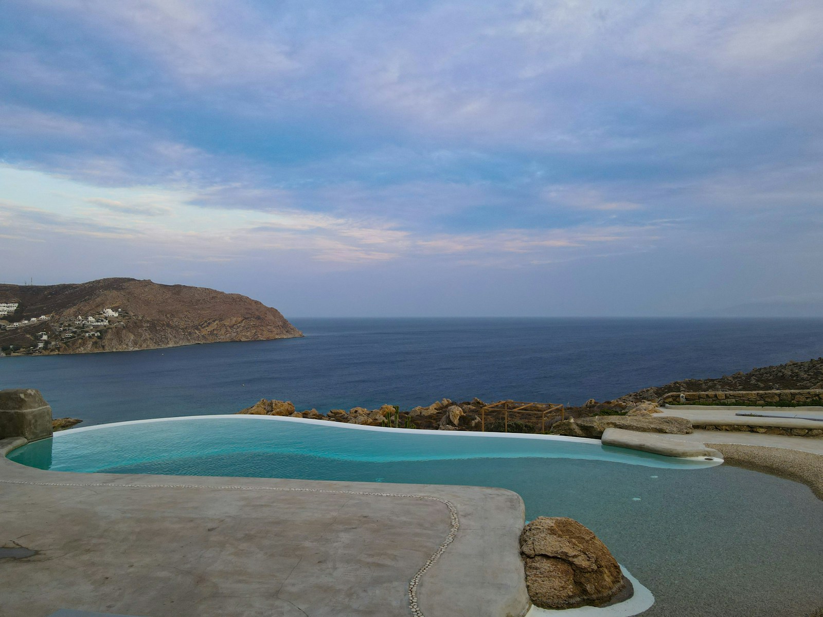 Whitewashed Greek villa with infinity pool overlooking the caldera at sunset