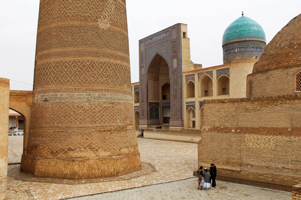 Minaret de brique et coupoles bleues dans la vieille ville de Boukhara au petit matin