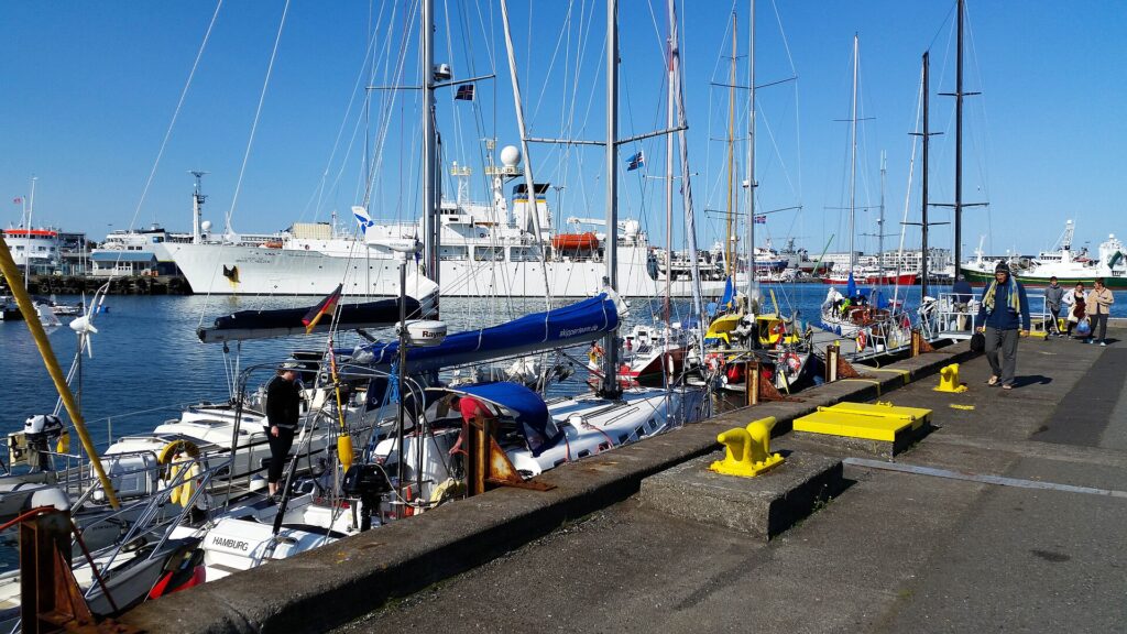 Pontons de marina alignés avec des voiliers amarrés côte à côte, passerelles et cordages visibles