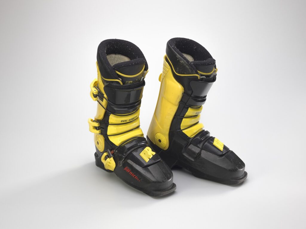 Chaussures de ski align&eacute;es sur un s&eacute;choir et paires de skis rang&eacute;es dans un local