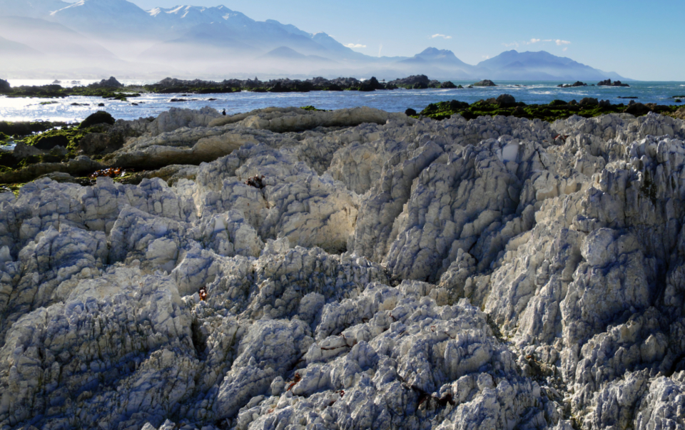 Côte rocheuse méditerranéenne plongeant dans une mer bleue, ciel dégagé et végétation basse