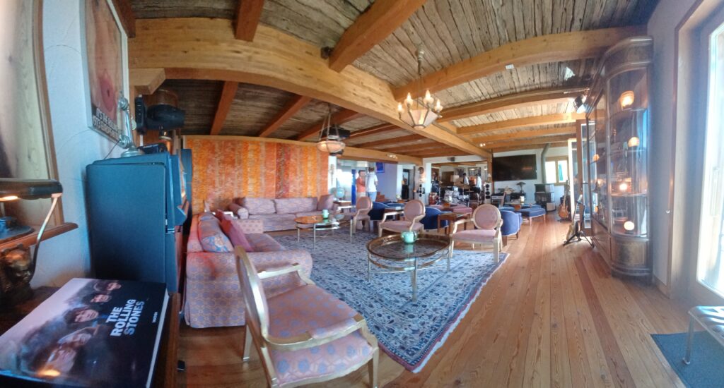 Salon de chalet avec cheminée allumée, canapés profonds et grande table en bois