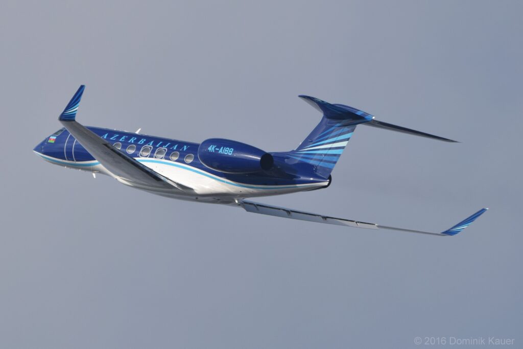 Jet d'affaires stationn&eacute; sur une aire enneig&eacute;e devant une barri&egrave;re de montagnes