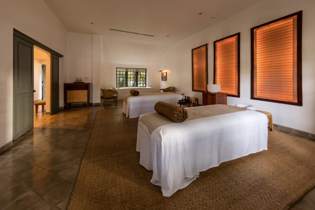 Table de massage pr&eacute;par&eacute;e dans une cabine de spa, serviettes pli&eacute;es et lumi&egrave;re tamis&eacute;e