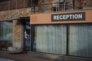 Comptoir de réception d'hôtel avec deux employés en uniforme et un registre ouvert