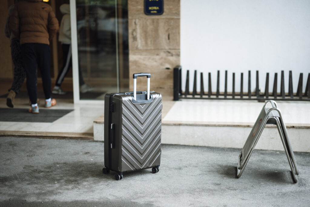 Valises encore ferm&eacute;es pos&eacute;es dans l'entr&eacute;e carrel&eacute;e d'une maison de vacances