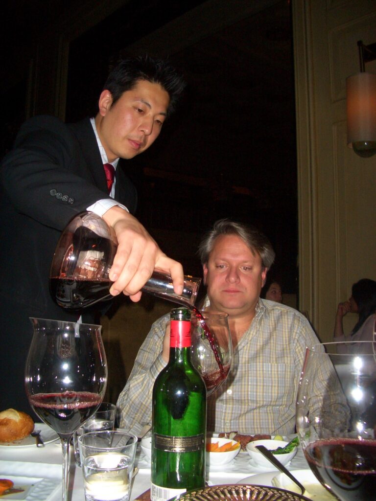 sommelier pouring red wine