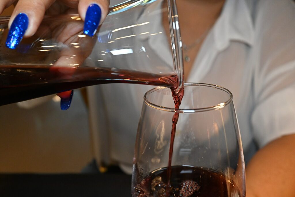 Verre de vin rouge et carafe sur une nappe blanche à la lumière d'une bougie