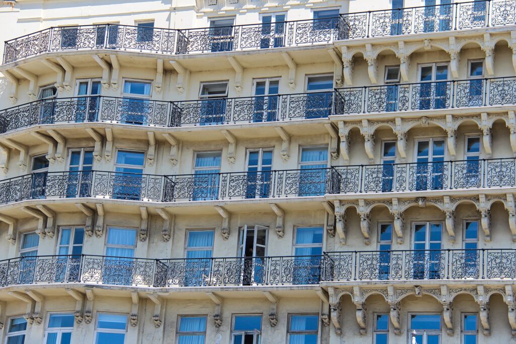 Balcon d'hôtel avec deux chaises face à une vue dégagée sur la mer au coucher du soleil