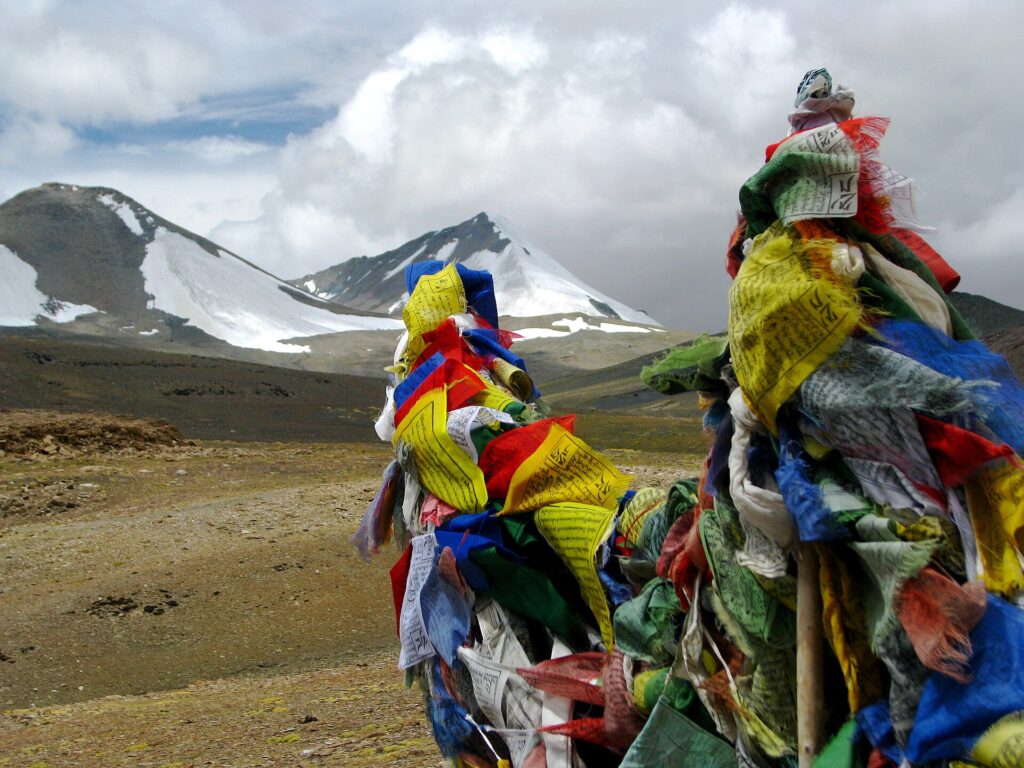 Drapeaux de prière tendus au sommet d'un col de montagne sous un ciel clair