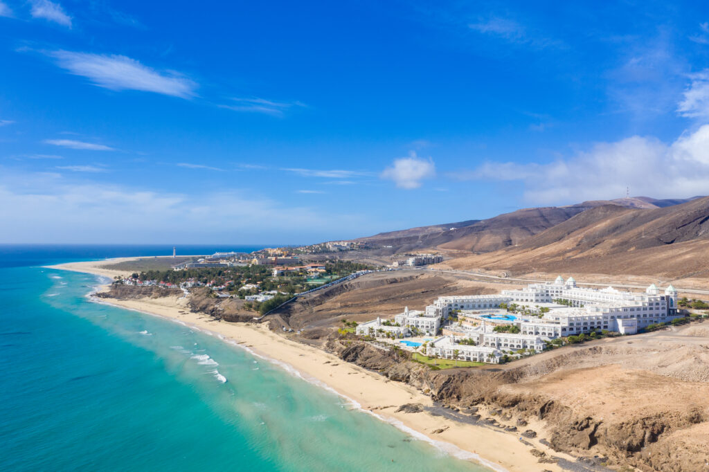 Vue aérienne d'une petite île bordée de bungalows sur pilotis et de récifs