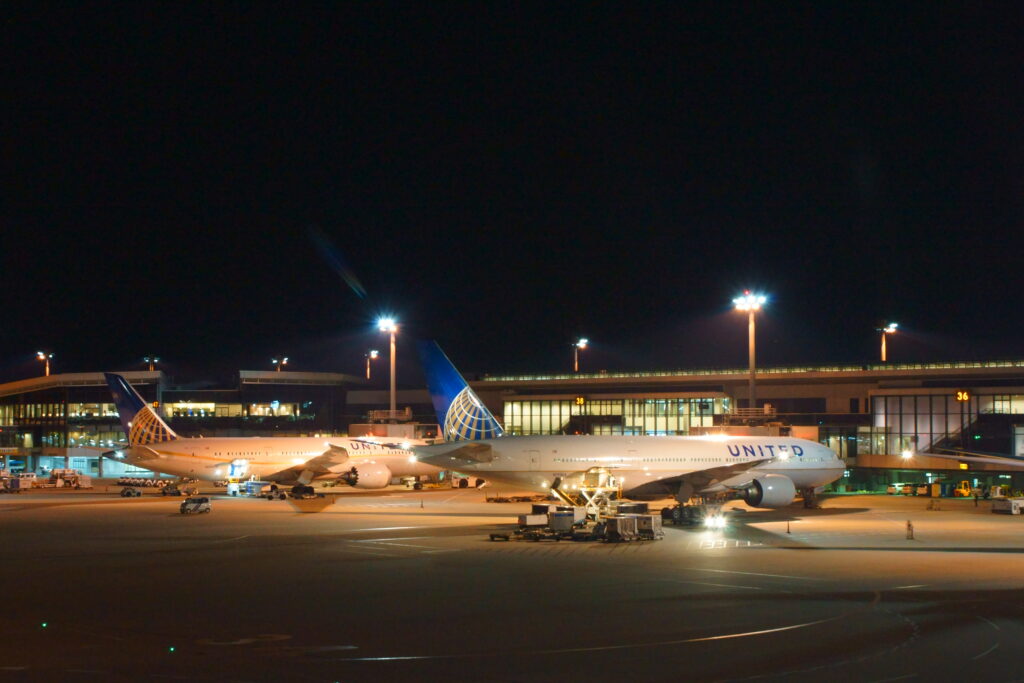 Aire de stationnement d'a&eacute;roport de nuit avec appareils align&eacute;s sous les projecteurs