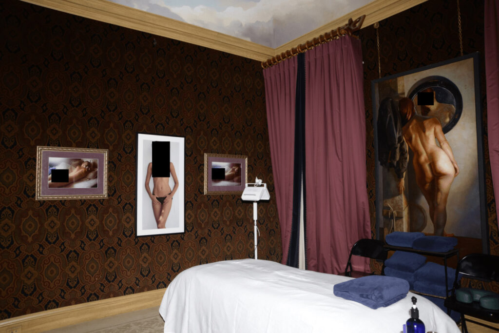 Salle de spa feutrée avec table de massage, bougies et serviettes roulées