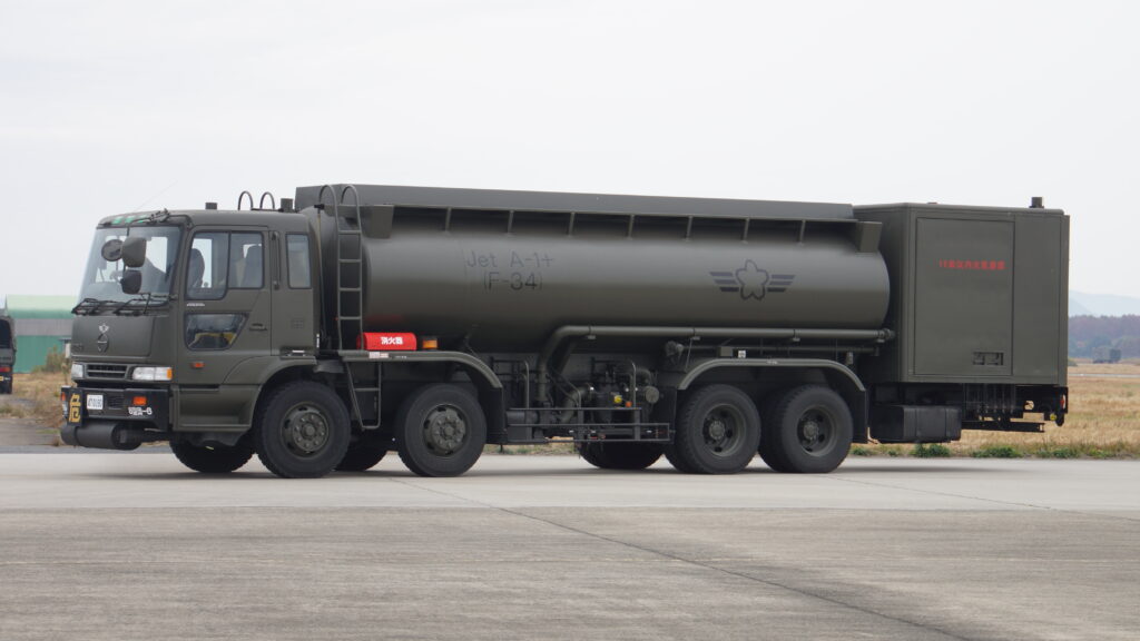 Camion avitailleur raccordé à l'aile d'un avion sur une aire de stationnement