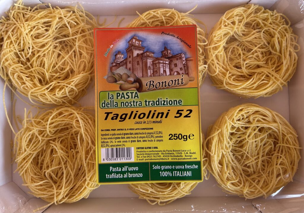 Assiette de p&acirc;tes fines au beurre sur une nappe blanche, pr&ecirc;te &agrave; &ecirc;tre r&acirc;p&eacute;e