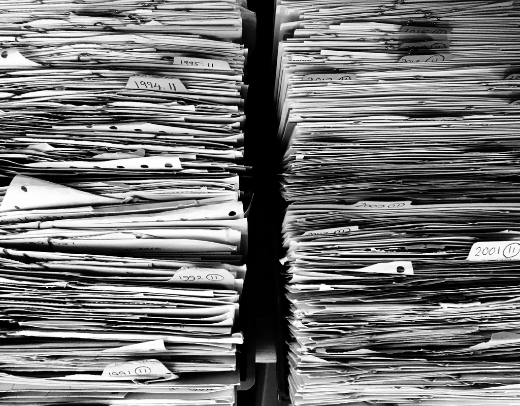 Chemise cartonnée ouverte contenant des documents classés sur un plan de travail