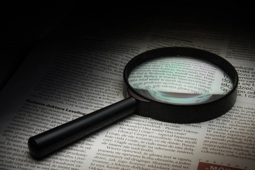 Loupe posée sur un texte imprimé en petits caractères dans un document contractuel